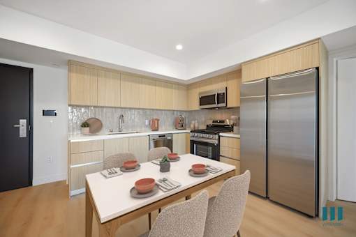 A modern kitchen with a dining table set for two.