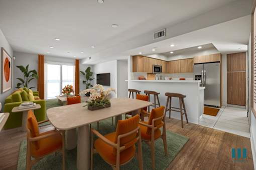 Open-Concept Kitchen with Countertop Bar, Dining, and Living Room with a Patio