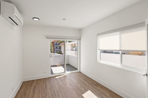 Bedroom with Windows, Vinyl Flooring, and Patio