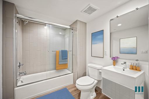 A bathroom with a white toilet, sink, and bathtub.