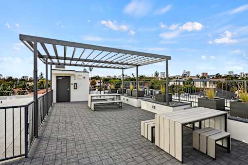 A patio with a table and chairs under a roof.