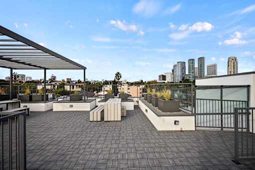 A rooftop patio with a metal railing and a metal awning.