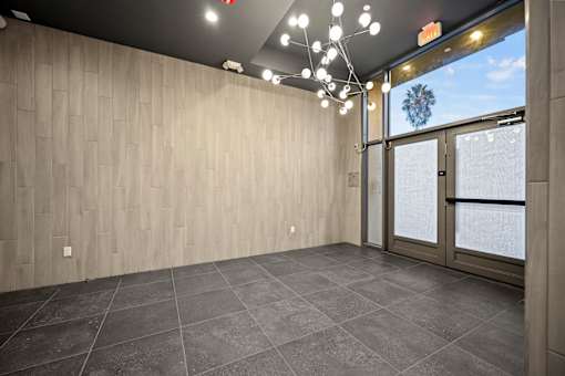 A room with a grey floor and wooden walls.