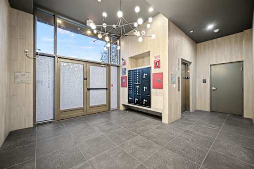 A modern office lobby with a reception desk and a large window.