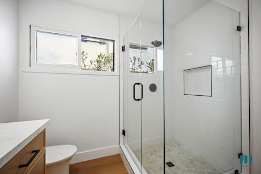 Bathroom with Walk-In Shower, VAnity Cabinet Storage, and Window
