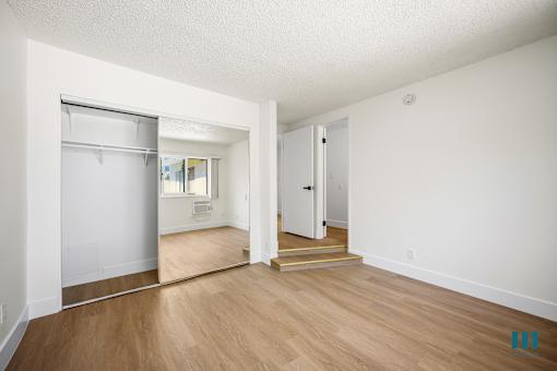 Bedroom with Vinyl Flooring and Mirrored Closet