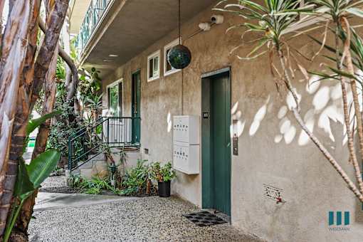 A building with a green door and a balcony with a metal railing.