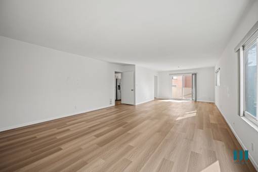 A room with wooden flooring and white walls.