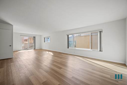 A room with wooden flooring and white walls.