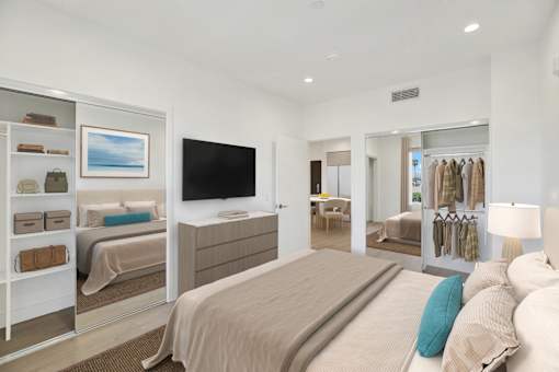 A bedroom with a large bed and a walk-in closet.