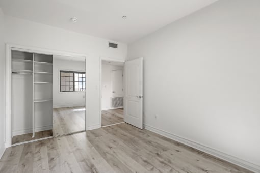 Bedroom with Closet with a Built-In Organization System and Vinyl Flooring