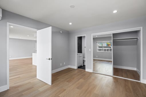 Bedroom with Mirrored Closet, Recessed Lighting, Vinyl Flooring, and Bathroom