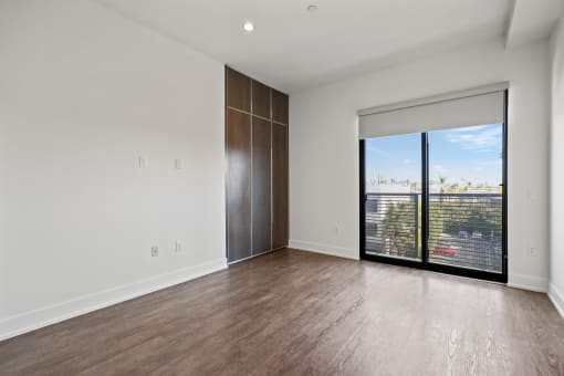 Bedroom with Built-In Cabinet Storage, Recessed Lighting, and Balcony with Windows with Shades