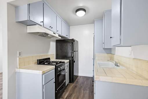 Kitchen with Refrigerator, Stove, and Vinyl Flooring *remodel in select units