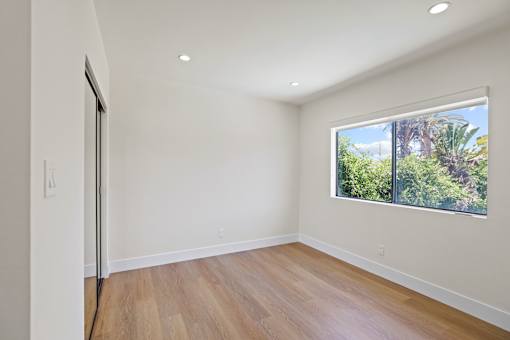 Bedroom with Large Windows, Mirrored Closet, Recessed Lighting, and Vinyl Flooring