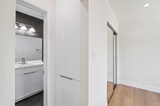 Bedroom with Built-In Cabinet Storage, Mirrored Closet, and Bathroom