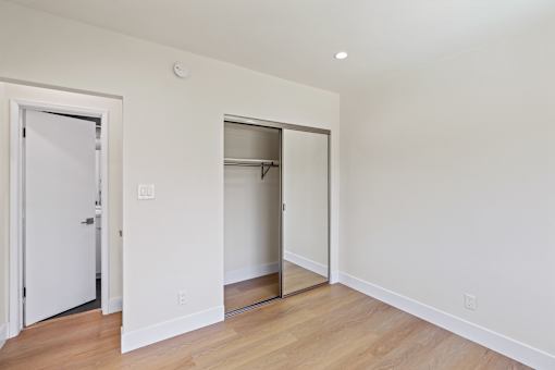Bedroom with Mirrored Closet, Vinyl Flooring, and Recessed Lighting