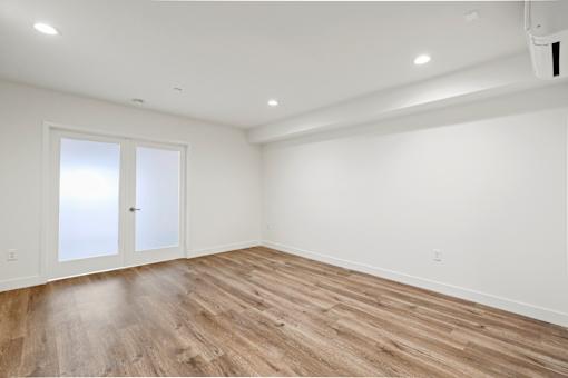 Large Bedroom with Double Doors, Recess Lighting, and Vinyl Wood Flooring