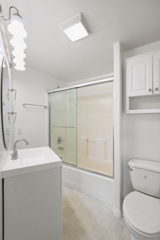 Bathroom with Bathtub with Glass Doors and Additional Storage Cabinet