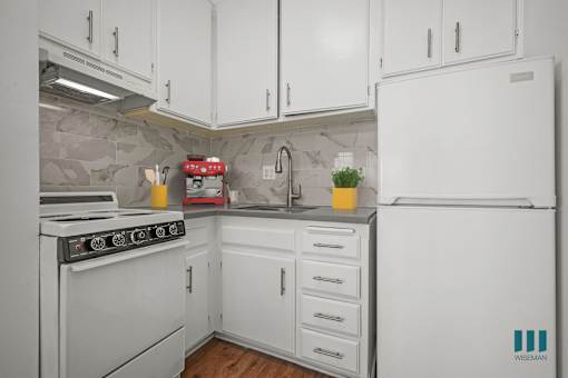 A kitchen with white appliances and cabinets.