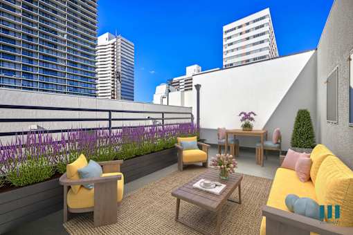 A modern outdoor seating area with yellow couches and wooden furniture.