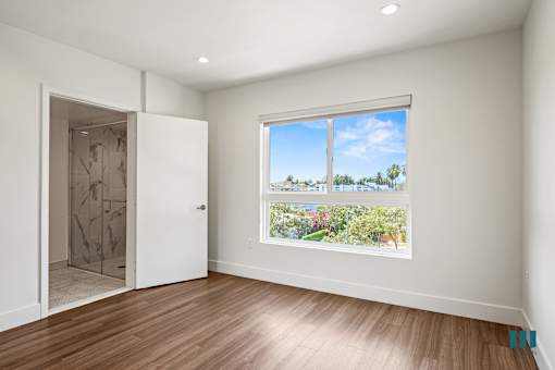 Bedroom with Large-Windows, Vinyl Flooring, Recessed Lighting, and Bathroom