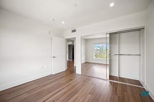 Bedroom with Vinyl Flooring, Recessed Lighting, and Mirrored Closet