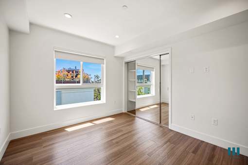 Bedroom with Vinyl Flooring, Recessed Lighting, and Mirrored Closet
