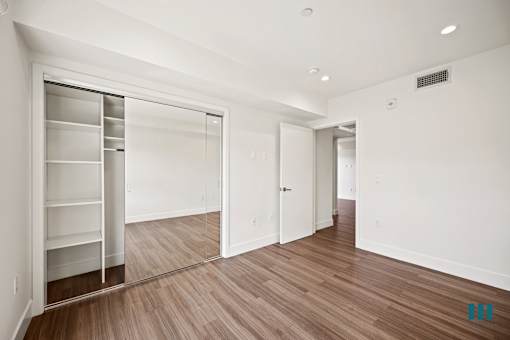 Bedroom with Mirrored Closet with Shelving, Recessed Lighting, and Vinyl Flooring
