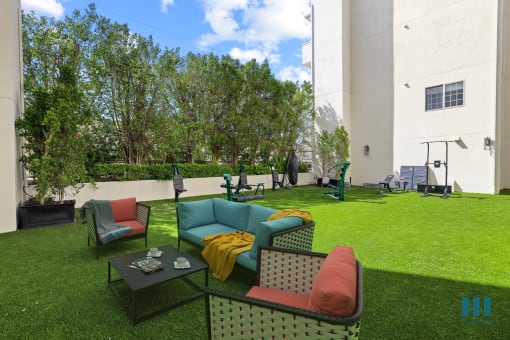 a lounge area with couches and chairs on the grass