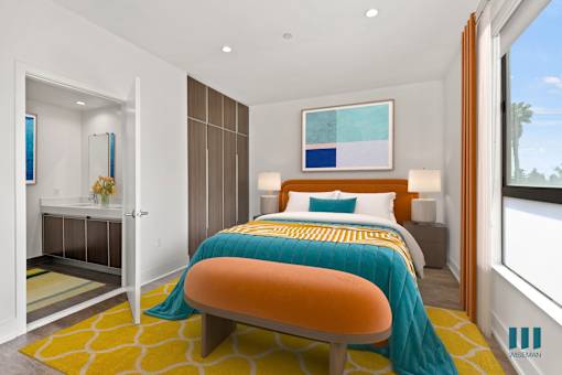 A bedroom with a bed, a chair, and a painting on the wall.