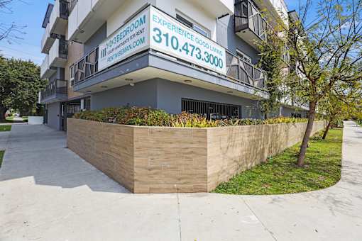 A building with a sign that says "Experience Good Living" and a phone number.