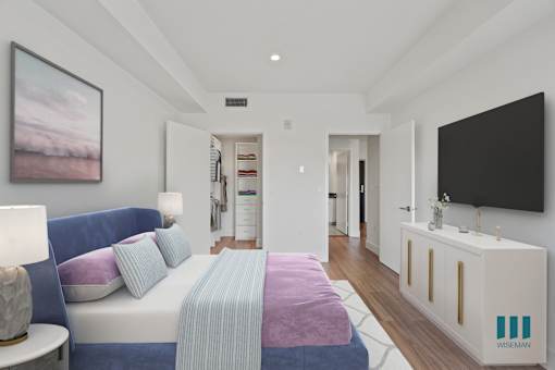 A bedroom with a bed, a nightstand, and a television.