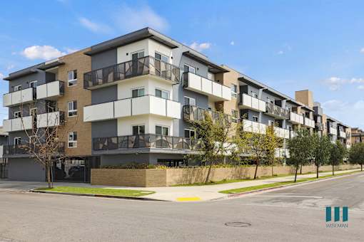 Apartment building with balconies and a clear sky.