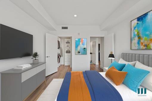A modern bedroom with a large bed and a painting on the wall.