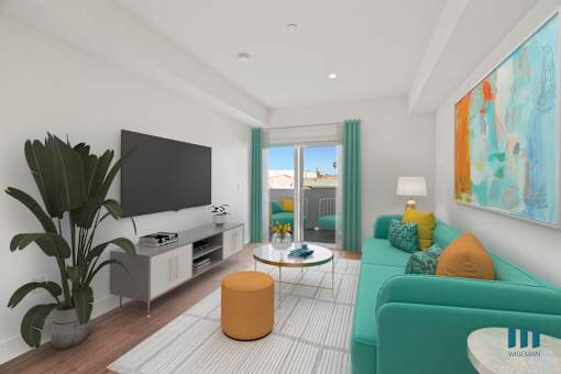 A living room with a television, a green couch, and a plant.