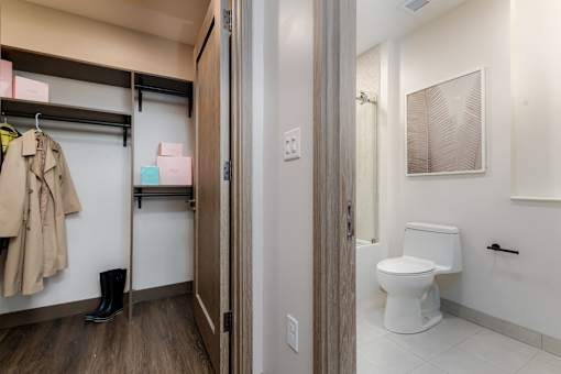 A bathroom with a toilet and a coat hanging up.