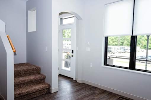 A hallway with a staircase leading to the second floor.
