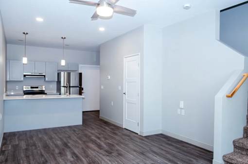 A kitchen with a stainless steel refrigerator and a ceiling fan.