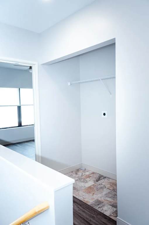 A white hallway with a door and a window.
