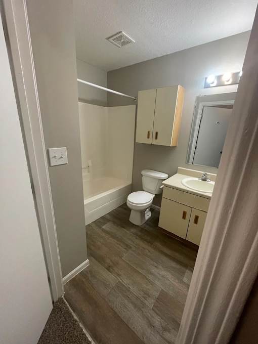 A small bathroom with a toilet, sink, and medicine cabinet.