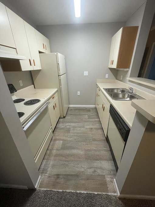 A kitchen with white appliances and cabinets.