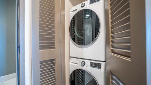 A stack of three washing machines in a laundry room.