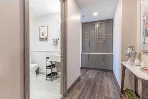 A bathroom with a toilet, sink, and a cabinet.