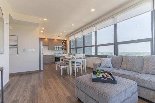 A modern living room with a grey couch and a wooden floor.