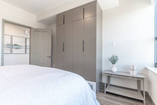 A bedroom with a large bed and a wooden cabinet.