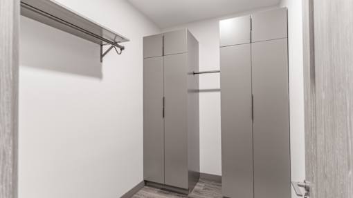A white room with a row of cupboards and a shelf above them.