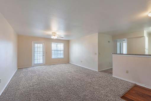 A spacious room with a carpeted floor and a bar area.