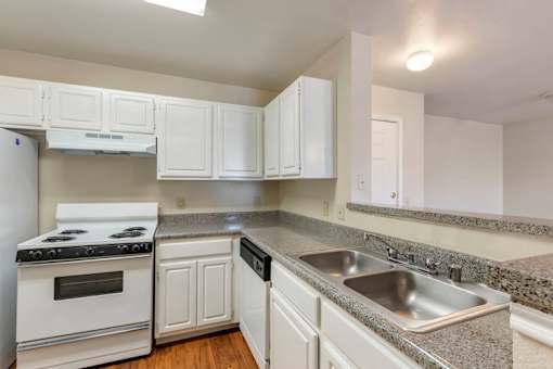 A kitchen with white cabinets and a stove top oven.