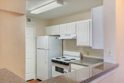 A kitchen with white appliances and cabinets.